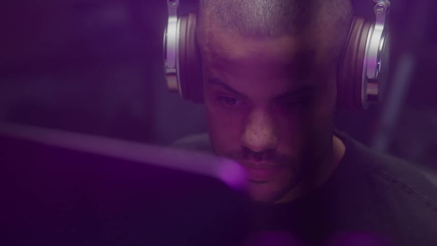 Man working on a computer briefly consults another source