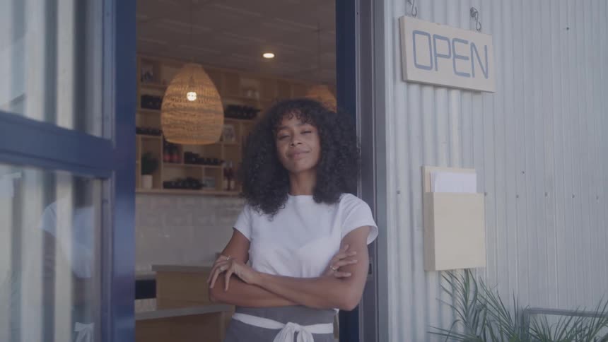 The worker leans on the doorway of the restaurant
