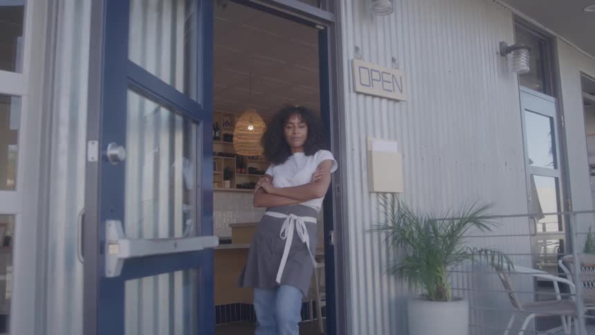 The worker stands in the doorway of the restaurant