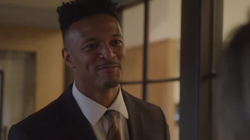 A man laughs while talking with a coworker