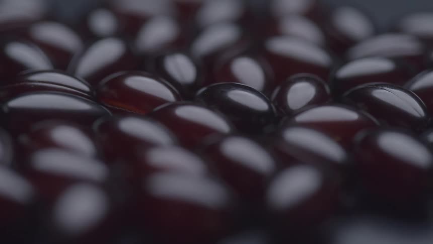 Shiny dark capsules clustered in closeup