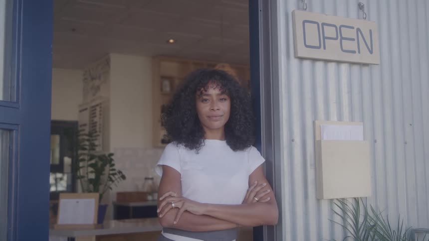 The worker stands in the doorway of the open restaurant