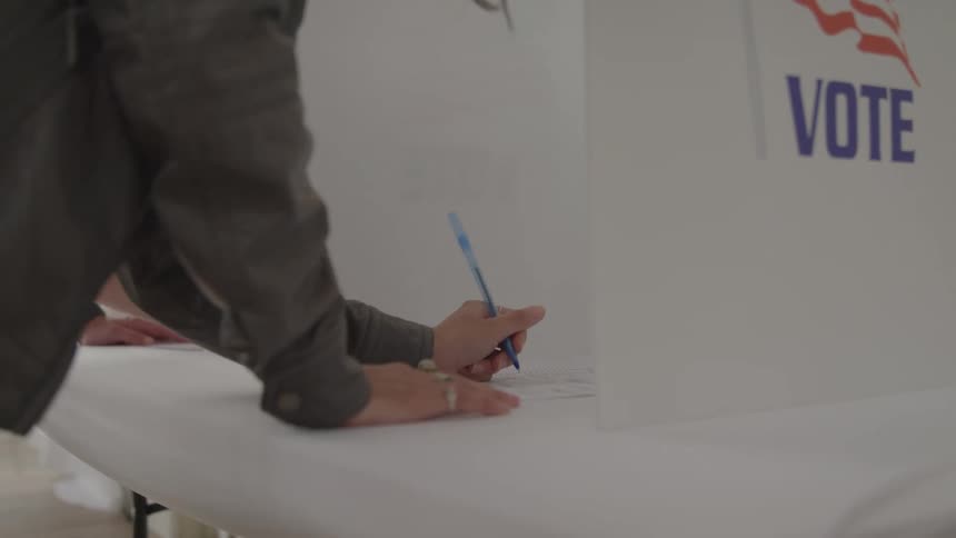 People are writing and voting in the booths