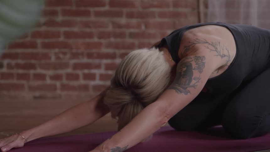 People are on mats in a building doing yoga