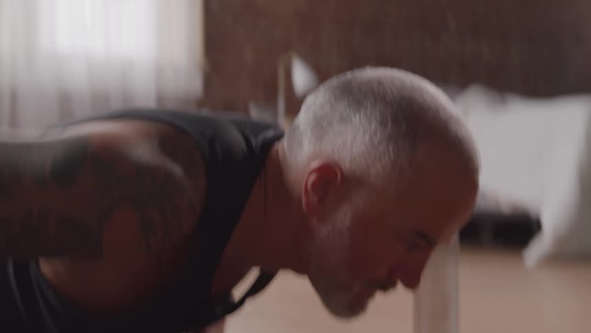A man performs several push ups in a row while exercising at home