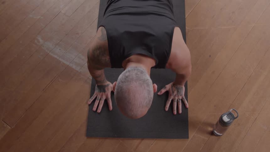 The man does push ups on the mat