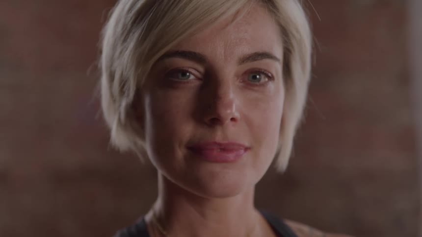 A woman with short blonder hair turns her head to the left