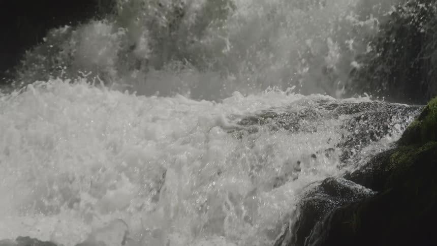 Fast flowing water splashes downward as it flows downhill