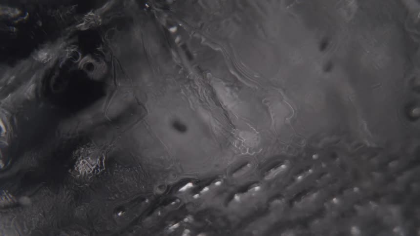 The video shows two lines in the water that appear to be moving away from each other the lines are visible in the turbulent swirling water but they dont seem to be bubbles