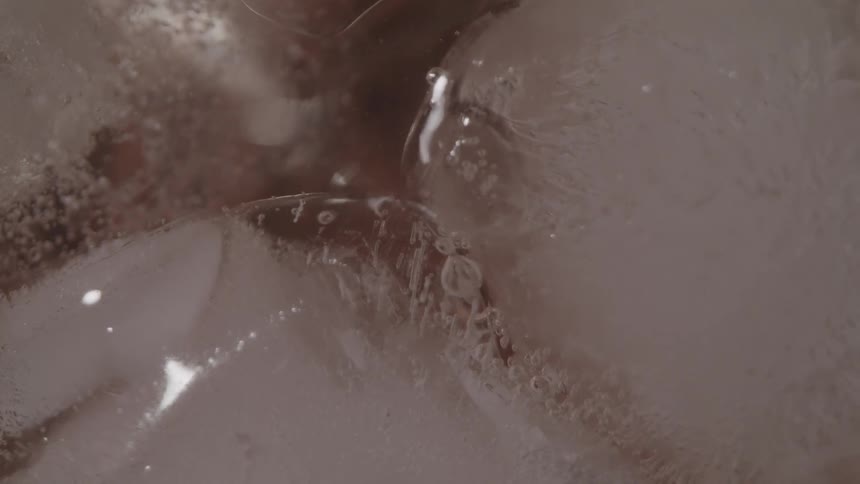 Small bubbles escape to the surface of liquid with ice cubes floating in it
