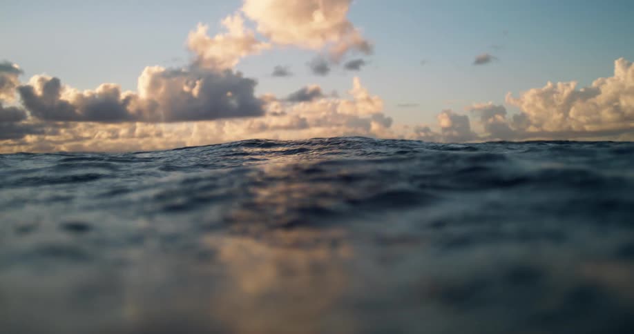 Flowing water waves on the ocean surface at sunset