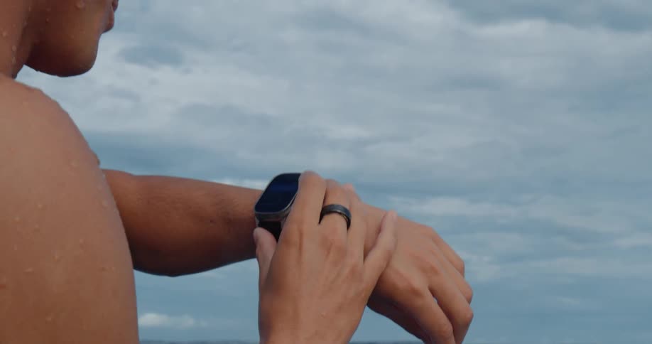 The man is checking his watch in the water
