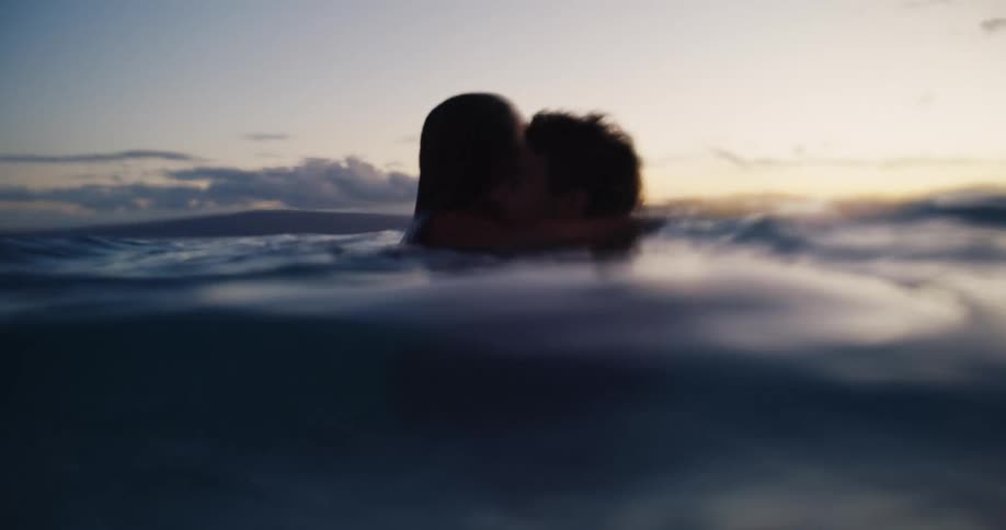 The couple kiss and hug in the water together