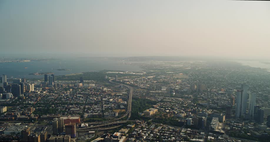 Aerial view of coastal city shows buildings highways and the sea in the background