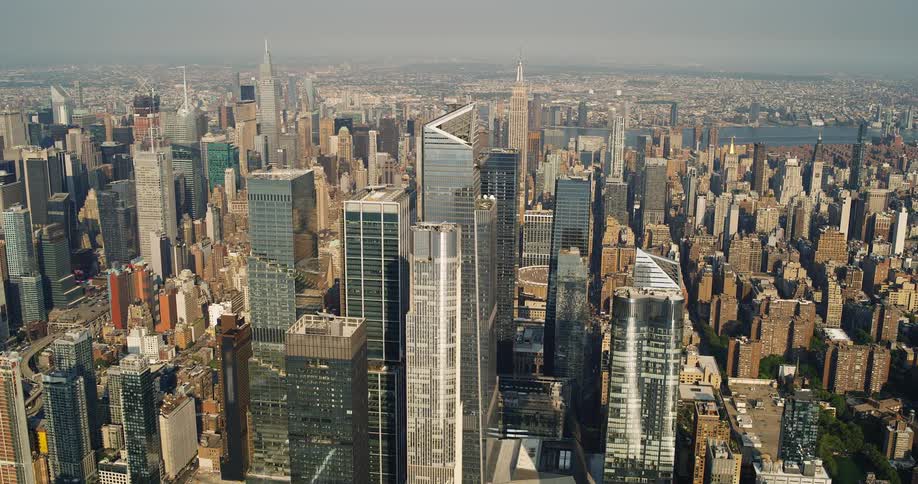 The video shows a highangle shot of a sprawling city skyline the camera slowly zooms out revealing a vast urban landscape filled with numerous skyscrapers and buildings