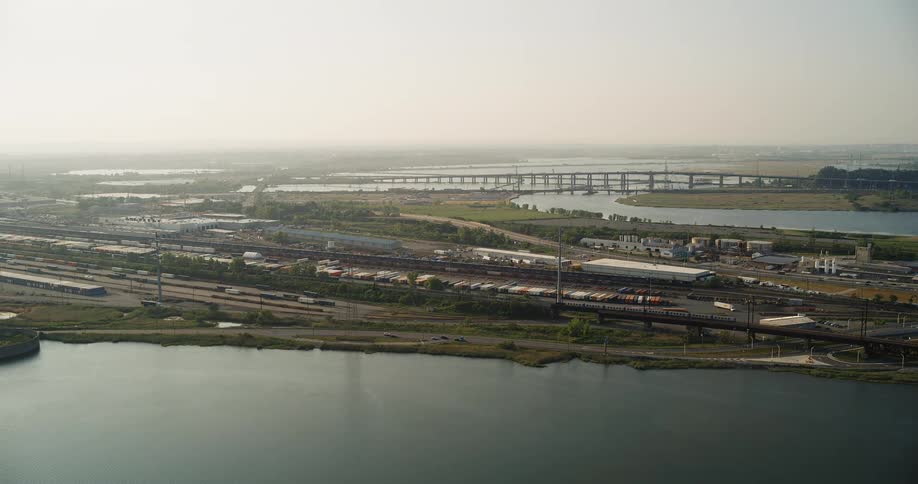 Trains and vehicles travel by the shore