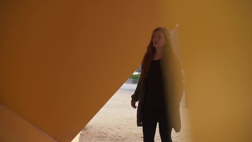 Woman walks through a yellow structure
