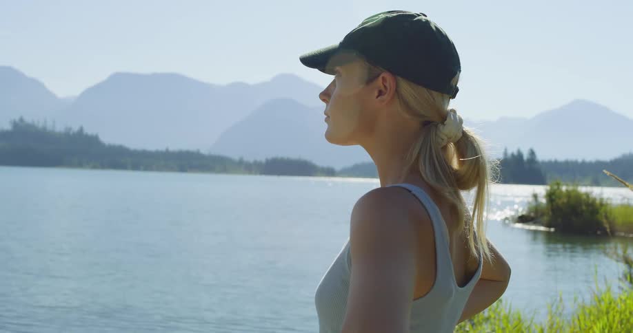 Woman stands on the shore on a foggy summer day and looks around