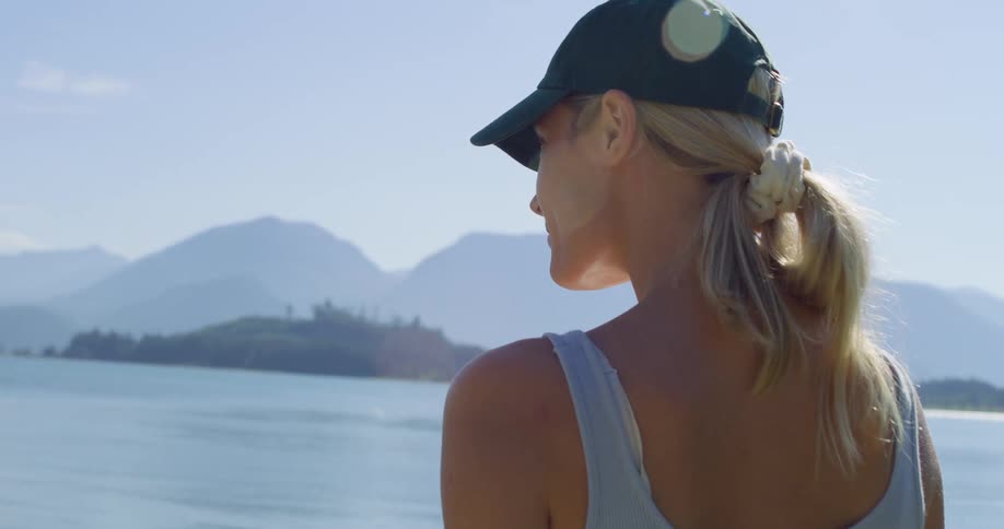The woman looks out over the lake