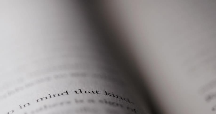 The words on the page of a book become blurry as the camera moves closer