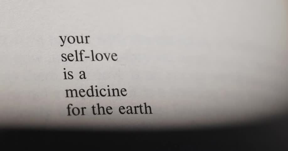 The video shows a closeup shot of a page from a book with the following quote your selflove is a medicine for the earth the text is clearly visible for the first five seconds before the shot goes out of focus