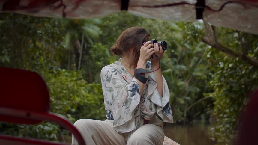The woman takes photos in the moving row boat
