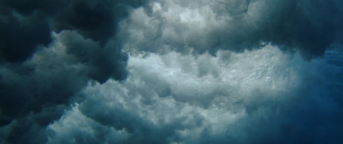 Wave foam spreads beneath the ocean surface