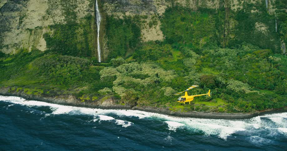The helicopter flies over the shore line
