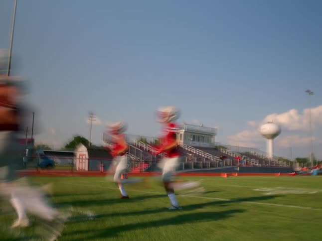 Football players sprint across the green field