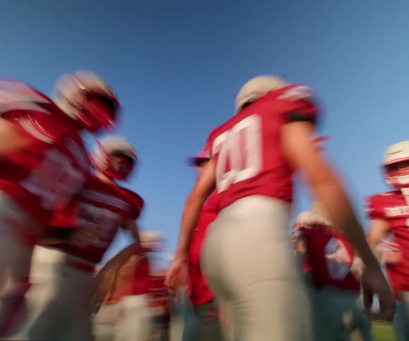 A group of people in full gear get ready to play football on a field