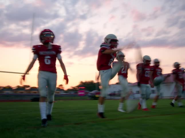 A football team does dynamic exercises on the field