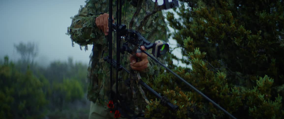 The man lifts up his bow and aims