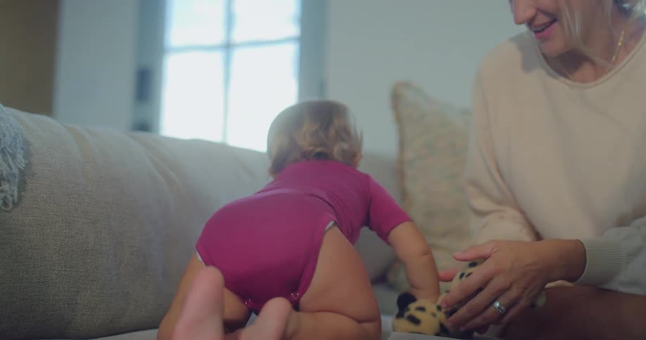 A baby crawls on the couch