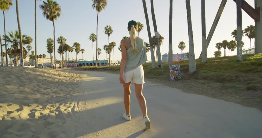 The woman walks on the path on the shore
