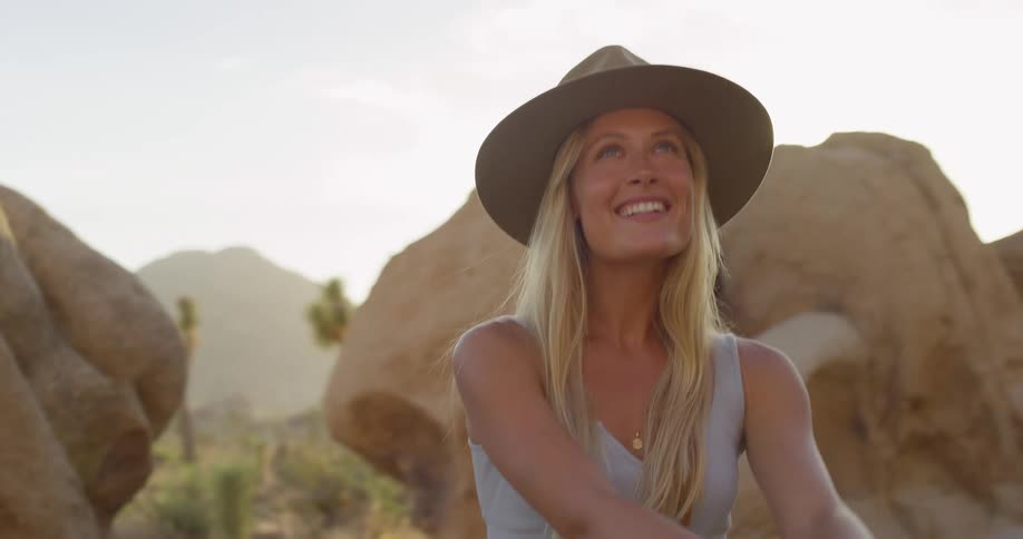 The woman smiles while hiking in the canyon
