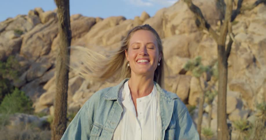 The woman jogs and smiles in the desert