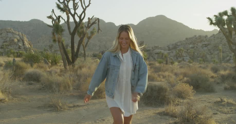 The woman smiles while jogging in the sand