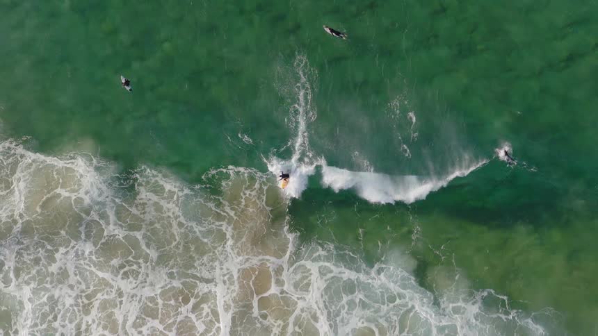 Aerial birds eye view of surfing on a wave in the ocean