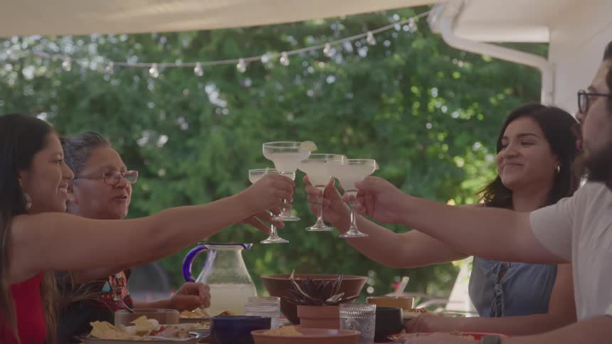 People toast their drinks and smile