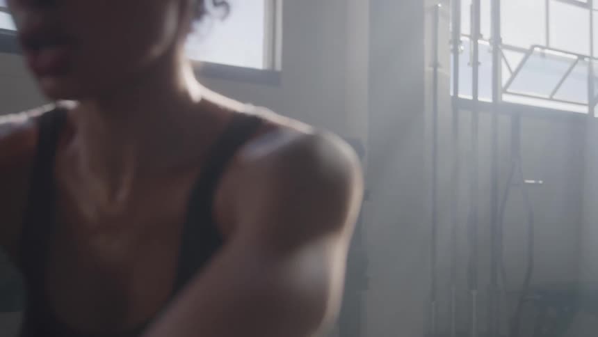 Woman works out in a gym using a resistance cable