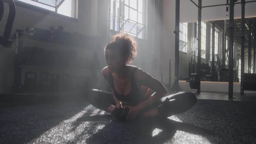 The woman is stretching in the gym