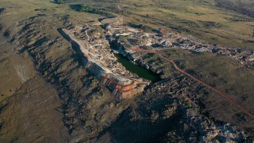 Aerial view of a quarry with a central lake surrounded by rocky areas