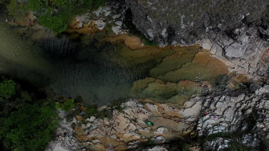 Aerial of a flowing stream between rocks outdoors during daytime