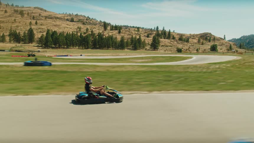 A firstperson perspective shows a gokart speeding around a curved track the camera captures the ground rushing by as the kart navigates the turn