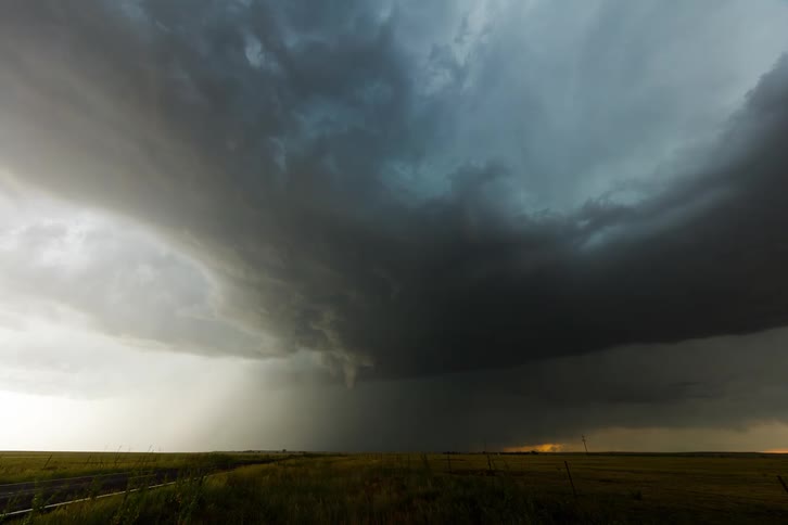 Heavy storm clouds form over an open field