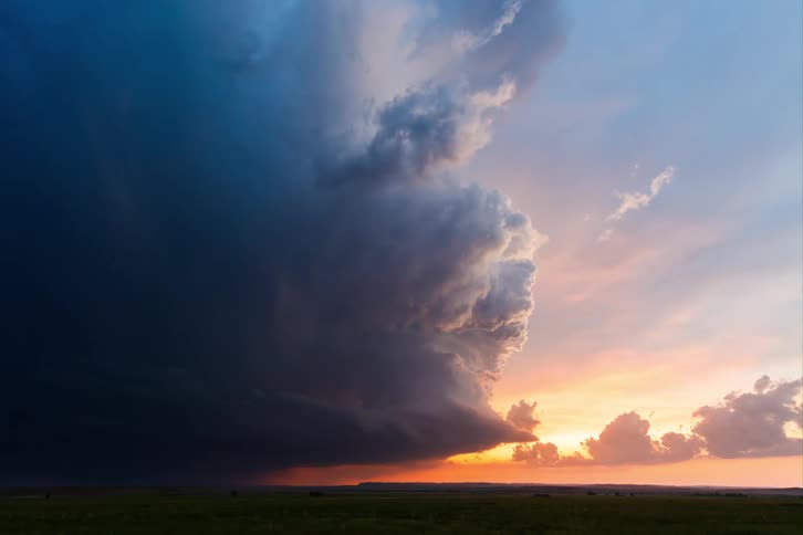 Dark storm clouds contrast with the orange sunset