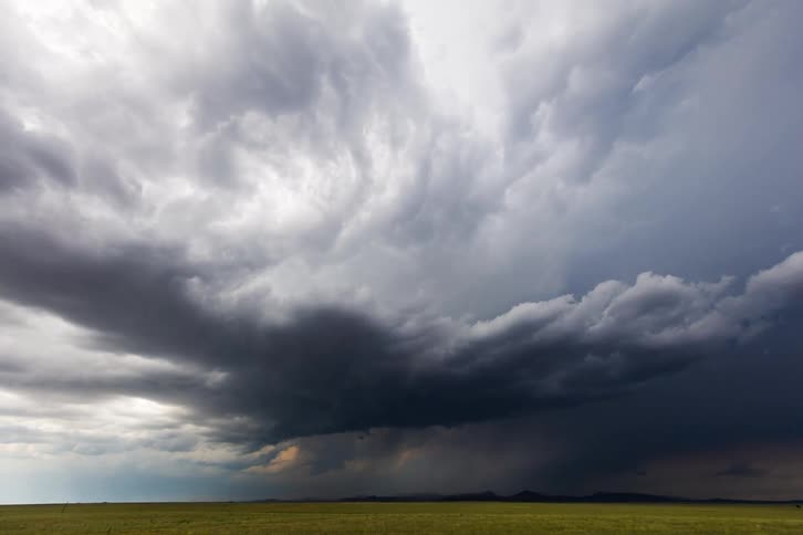 Dark storm clouds move over an open field