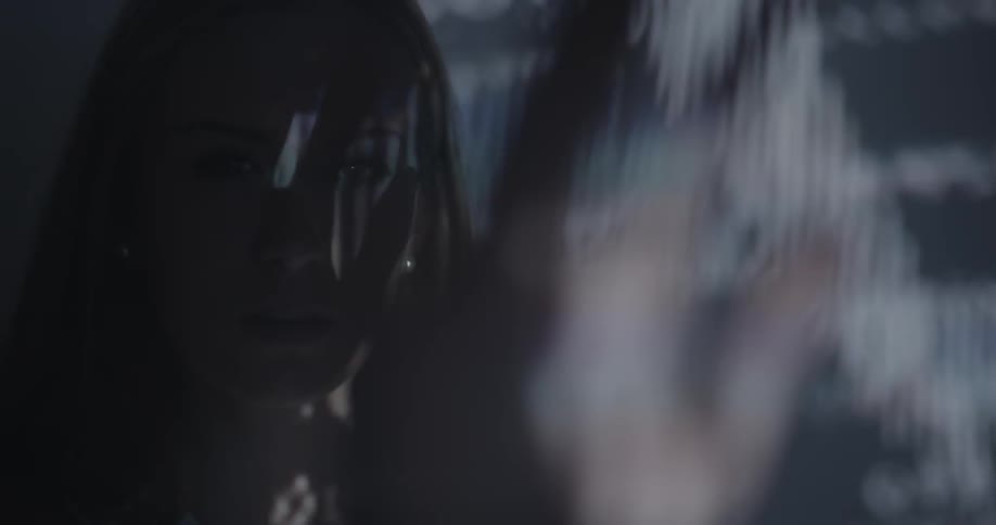 A woman stands in front of a spastic projection