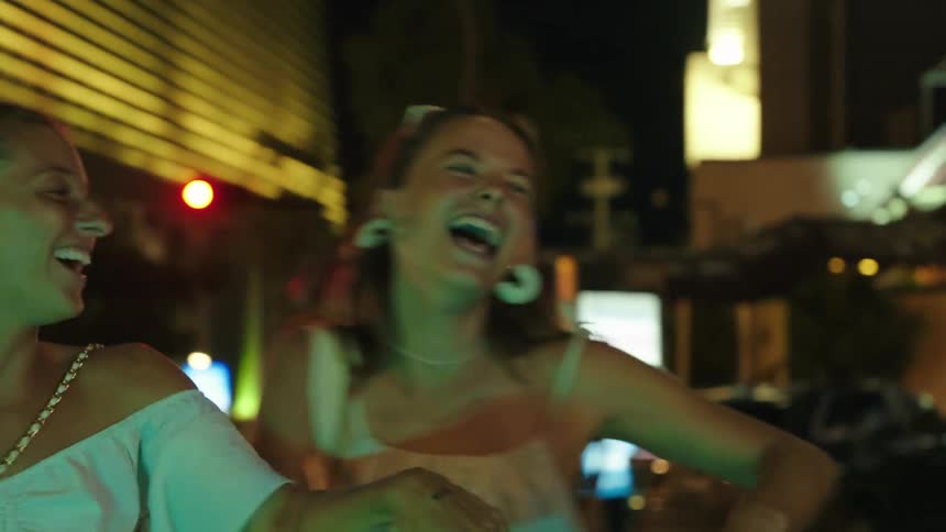 Two women dance together at night