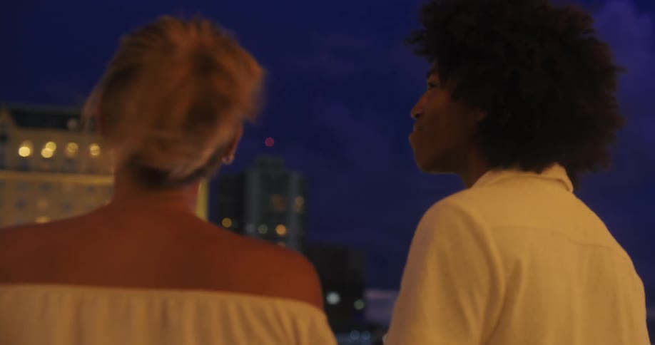 Friends talk while watching the clouds light up from a storm